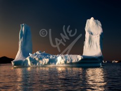 Iceberg with twin towers at sunset